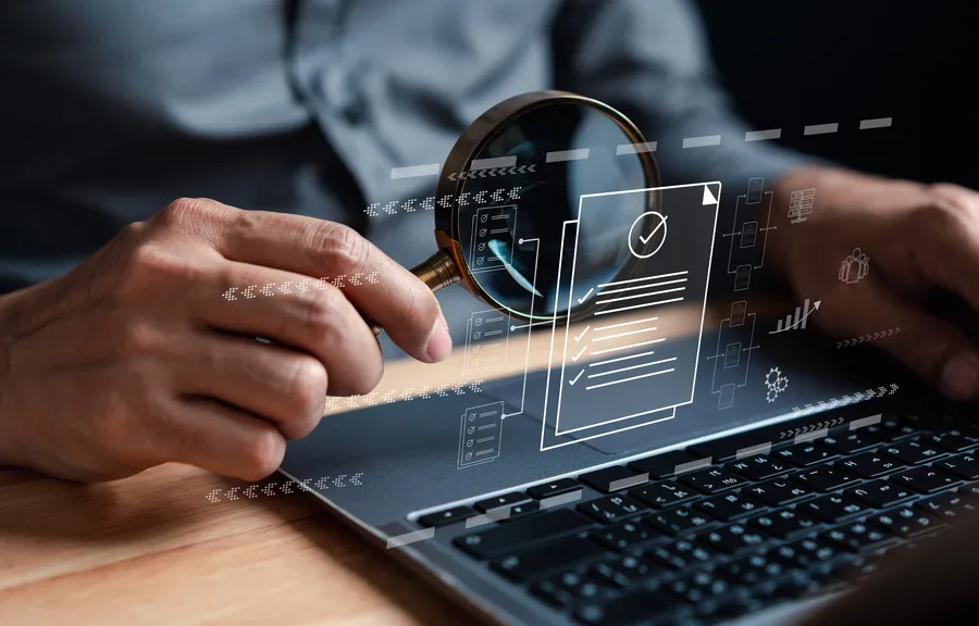 Magnifying glass examining digital documents and checklists